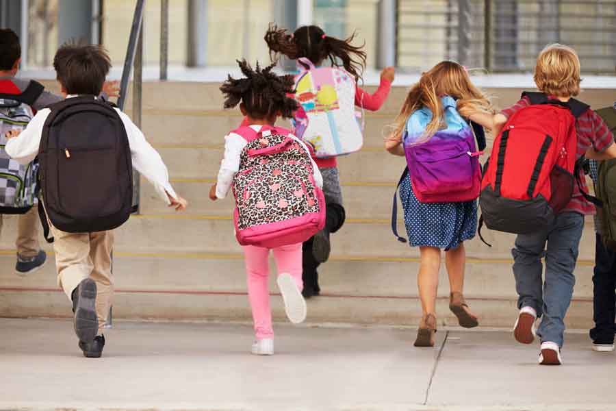 Children running towards school building